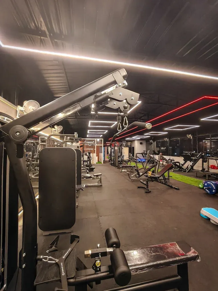 Lat pulldown and machine floor under the red ceiling lights