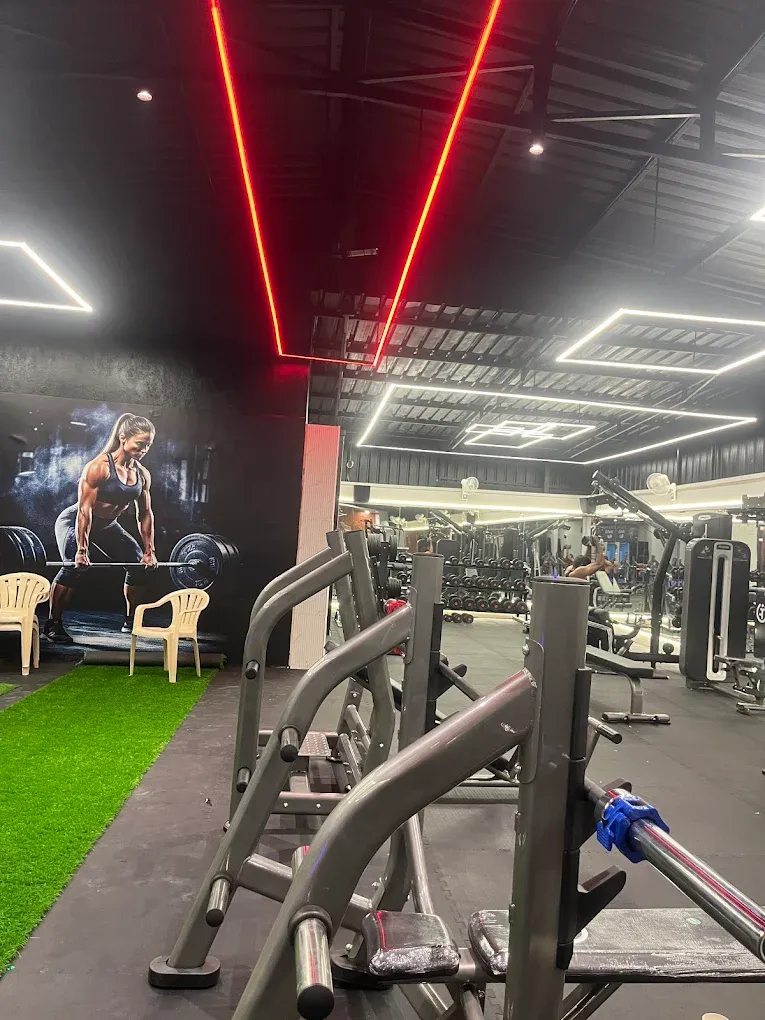 Hack squat and plate-loaded machines beside the turf at JP Fitness